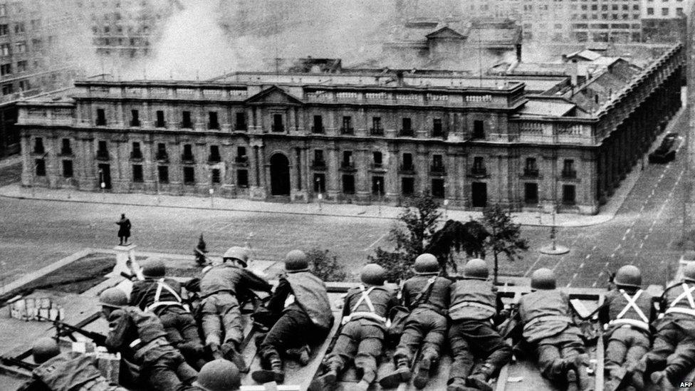 Chilean Army troops positioned on a rooftop fire on the La Moneda Palace in Santiago