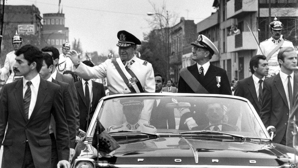 General Augusto Pinochet waves from the motorcade 11 September 1973 in Santiago