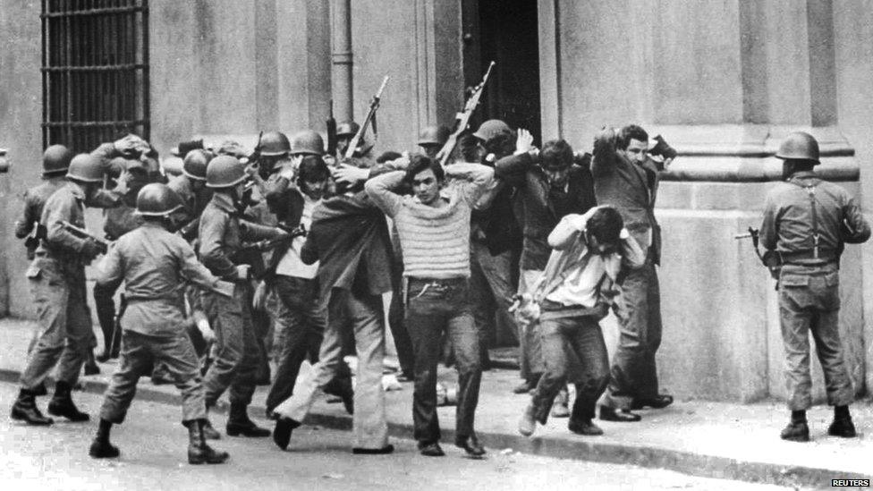 Aides and members of the presidency of former Socialist President Salvador Allende being guarded by soldiers outside La Moneda presidential palace in Santiago