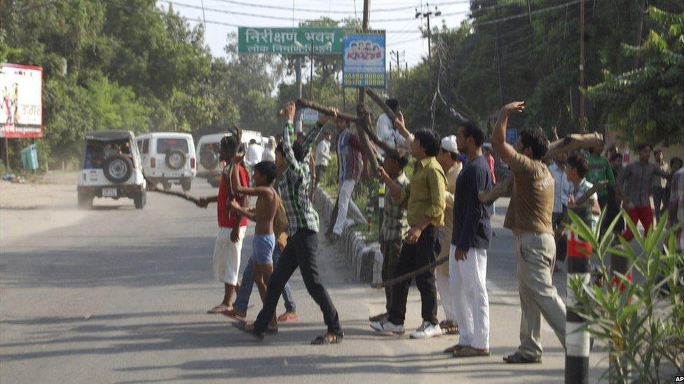 In this Saturday, Sept. 7, 2013 photograph, an unidentified group shouts slogans as Indian security forces arrive to quell communal clashes in Muzaffarnagar district, India