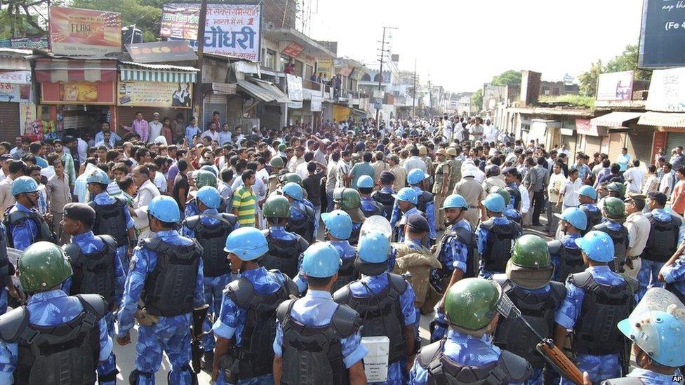 In this Saturday, Sept. 7, 2013 photograph, Indian security forces arrive following communal clashes in Muzaffarnagar district, India.