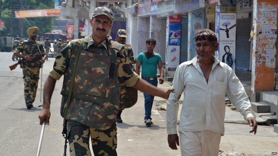 Indian soldiers detain two individuals following communal riots between Muslims and Hindus in Muzaffarnagar, India's Uttar Pradesh state, on September 9, 2013.