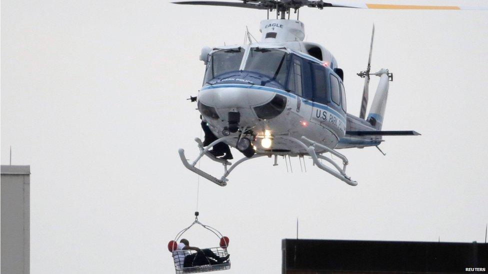 A helicopter rescues an apparent victim of a multiple shooting at the Washington Navy Yard, 16 Sept