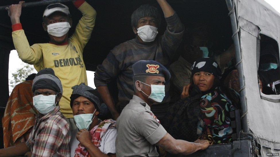 Villagers covered in ash sit on a truck while waiting to be evacuated to safety, as Mount Sinabung spews ash and hot lava during an eruption in Perteguhan village in Karo district, Indonesia's north Sumatra province, 17 September, 2013.