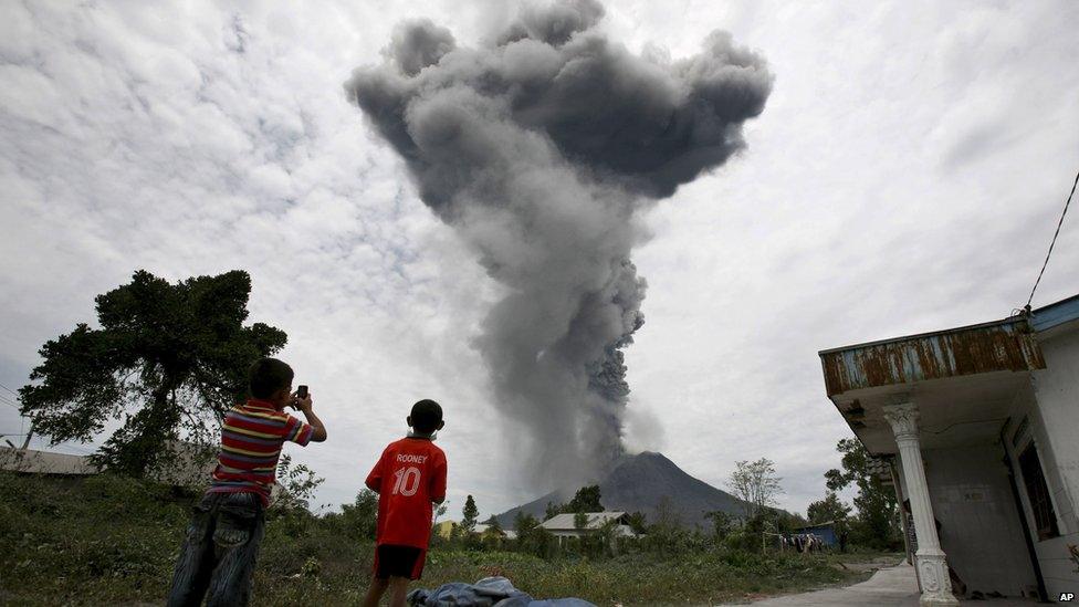 Indonesian youths watch as Mount Sinabung erupts in Karo, North Sumatra, Indonesia, Tuesday, 17 September, 2013.