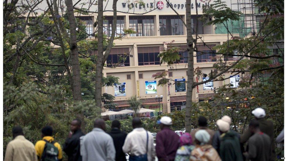 Onlookers gather on a hill to observe the Westgate Mall after a bout of heavy gunfire just after dawn in Nairobi, Kenya (23 Sept. 2013)