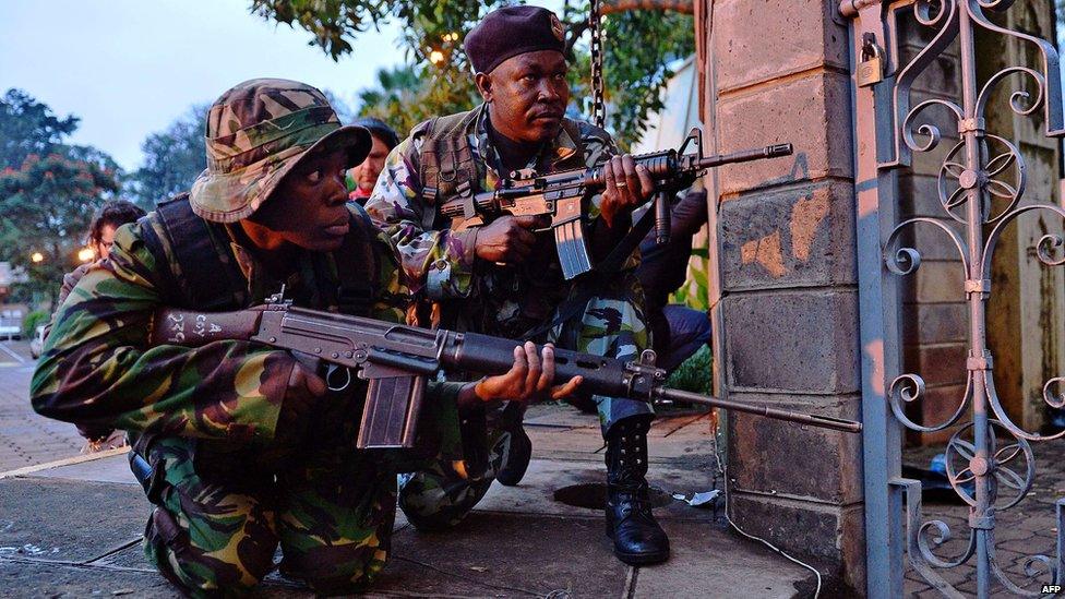 Kenyan soldiers take cover after heavy gunfire near Westgate mall in Nairobi (23 September 2013)