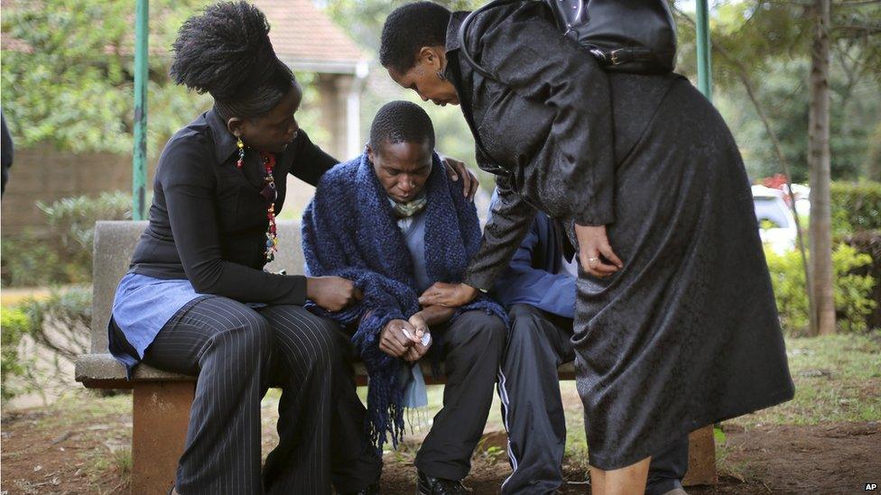 A grieving son is comforted as he waits outside the morgue (23 Sept 2013)