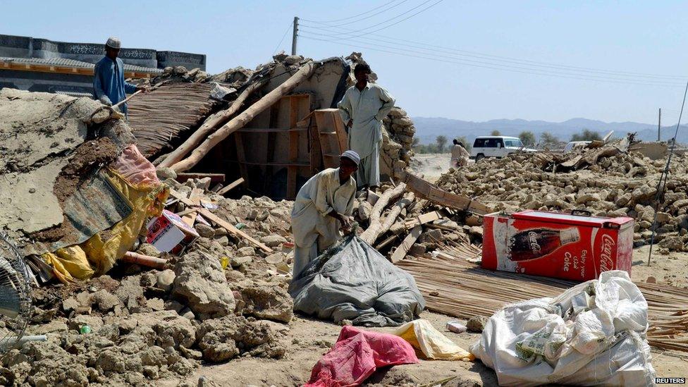 Survivors collect their belongings in the quake-hit town of Awaran, Balochistan, on 25 September 2013