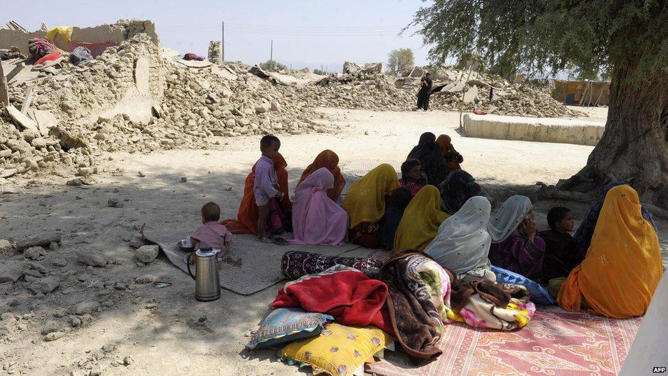 Quake survivors sit beside the debris of their destroyed homes in Awaran on 25 September 2013