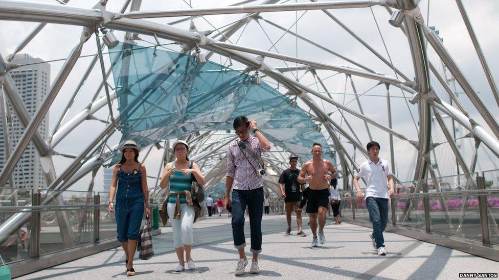 Tourists, joggers and office workers crossing Singapore's Helix Bridge