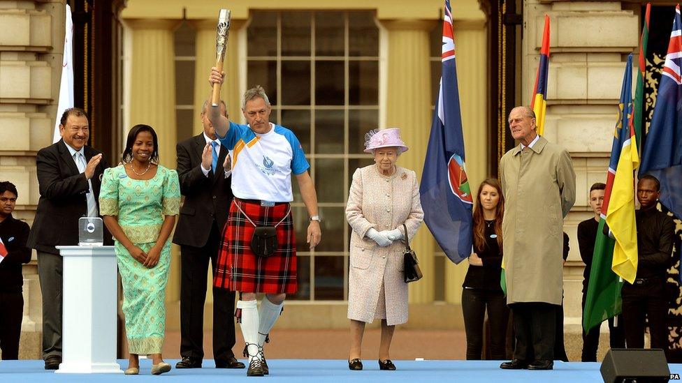 Allan Wells holds the baton aloft