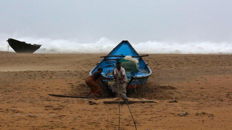 Fishermen tie their boat along the shore at Donkuru village in Srikakulam district, in the southern Indian state of Andhra Pradesh on 12 October 2012.