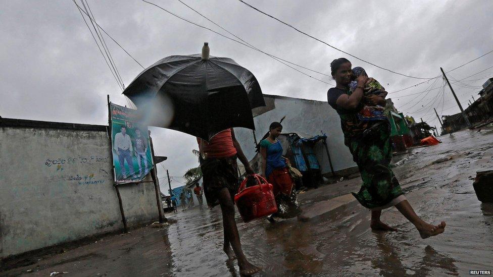 A woman carries her baby as she moves to a safer place with others at the village Donkuru in Srikakulam district in Andhra Pradesh state.