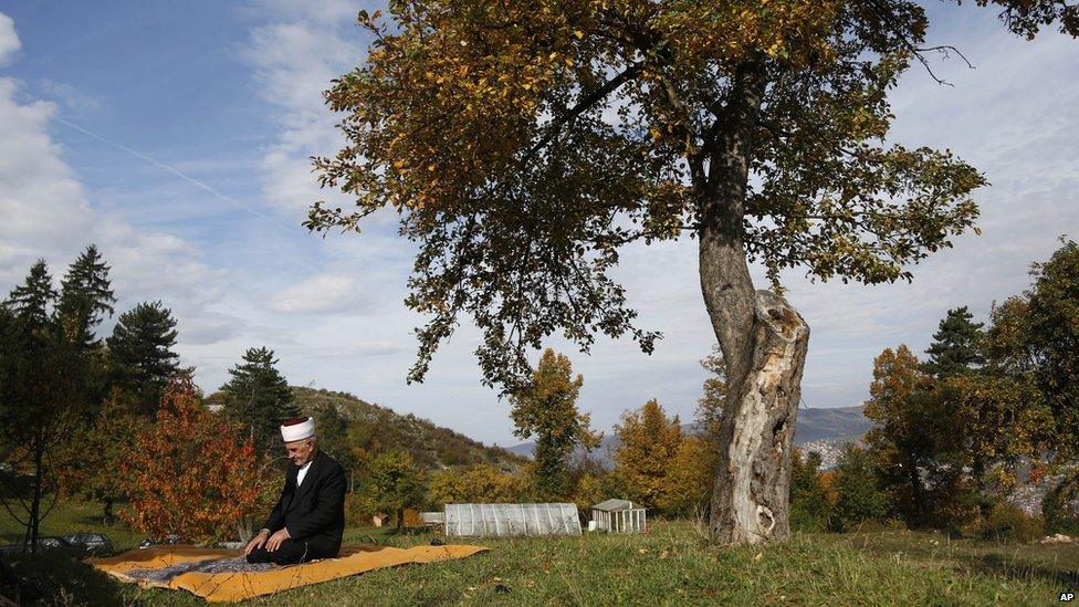 An elderly Bosnian Muslim prays outdoors in the outskirts of Sarajevo on 15 October 2013