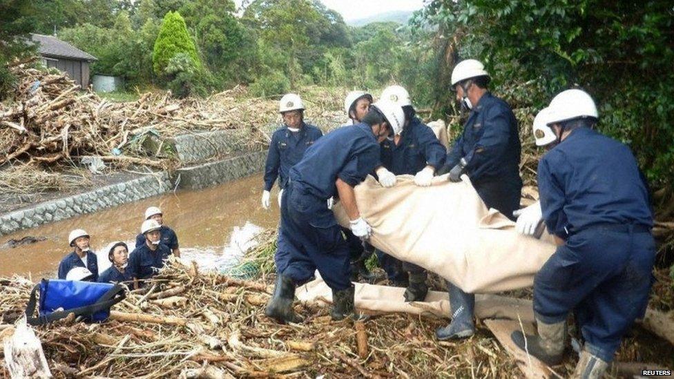 Rescue workers recover the body of a victim from a site that was damaged by a landslide caused by Typhoon Wipha in Izu Oshima island, south of Tokyo, in this photo taken by Kyodo, 16 October 2013