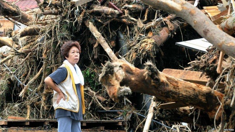 A woman reacts in front of collapsed houses following a landslide caused by Typhoon Wipha on Izu Oshima island, south of Tokyo, in this photo taken by Kyodo 16 October 2013