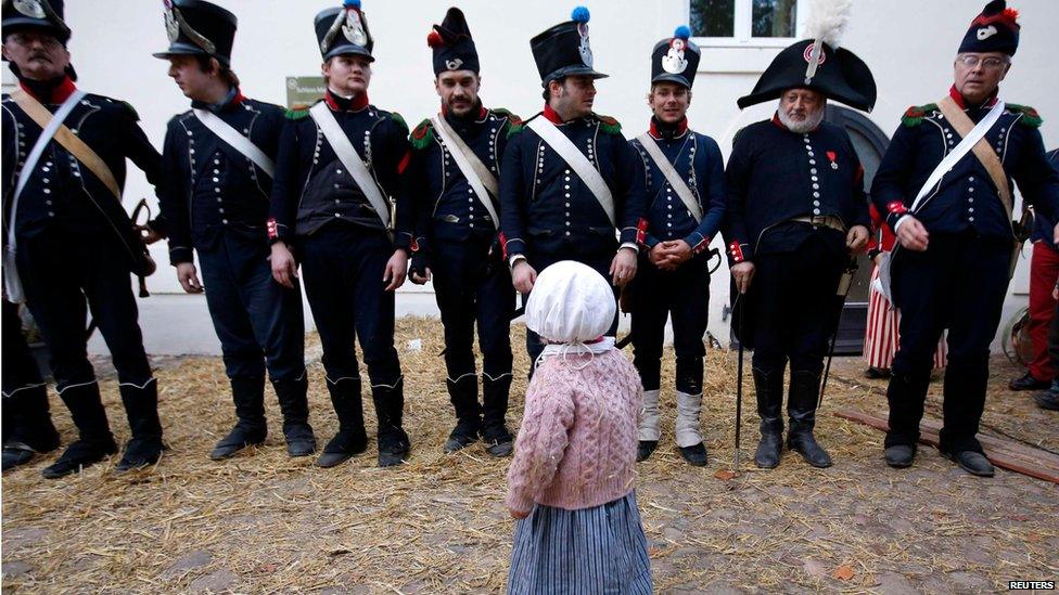 Girl in period costume looks at re-enactors dressed as French soldiers, re-enactment of the Battle of the Nations, Leipzig (20 October)