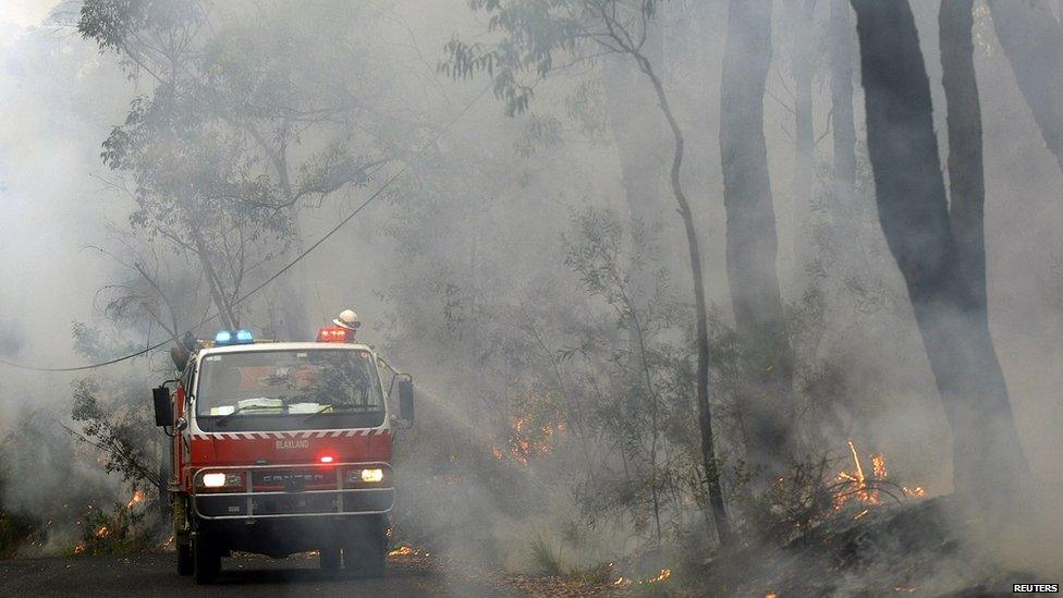 Rural Fire Service firefighters spray water on fire near home in the Blue Mountains suburb of Faulconbridge