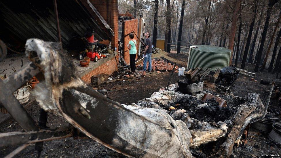 Jennifer Schweinsberg with her son David looks at her gutted house in Winmalee. 22 Oct 2013