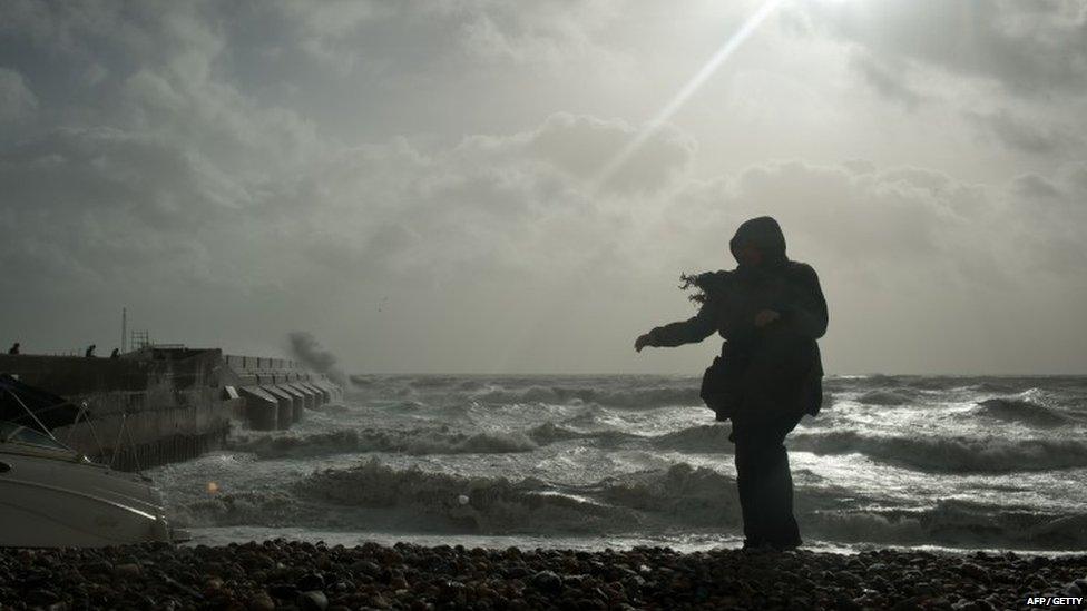 Waves roll into the beach and crash against the walls of Brighton Marina