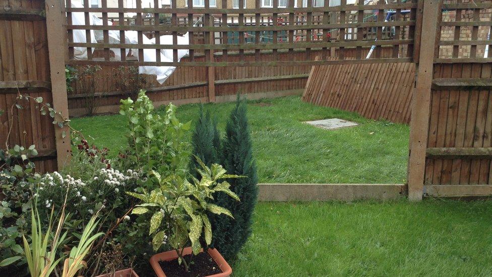 A broken garden fence. A missing panel has flown into the neighbour's garden.