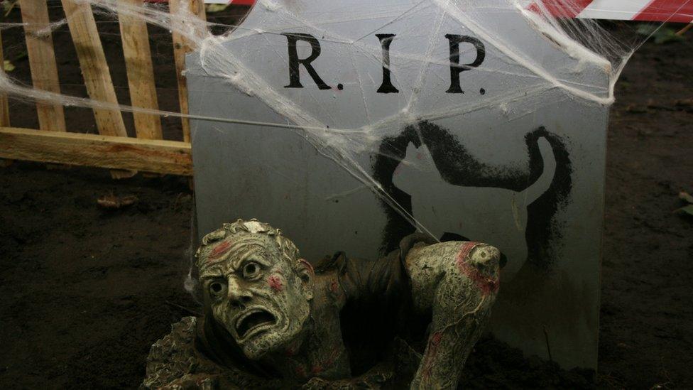 Grave with man coming out of it