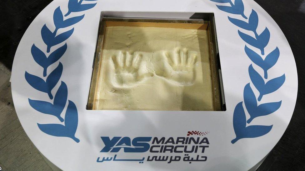 Sebastian Vettel's handprints are displayed in a Yas Marina Circuit logo