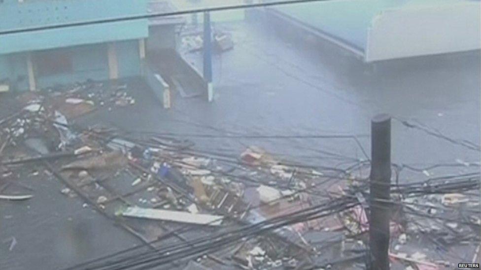 Debris float on a flooded road as strong winds and rain continue to batter buildings after Typhoon Haiyan hit Tacloban city, Leyte province, the Philippines, in this still image from video 8 November 2013