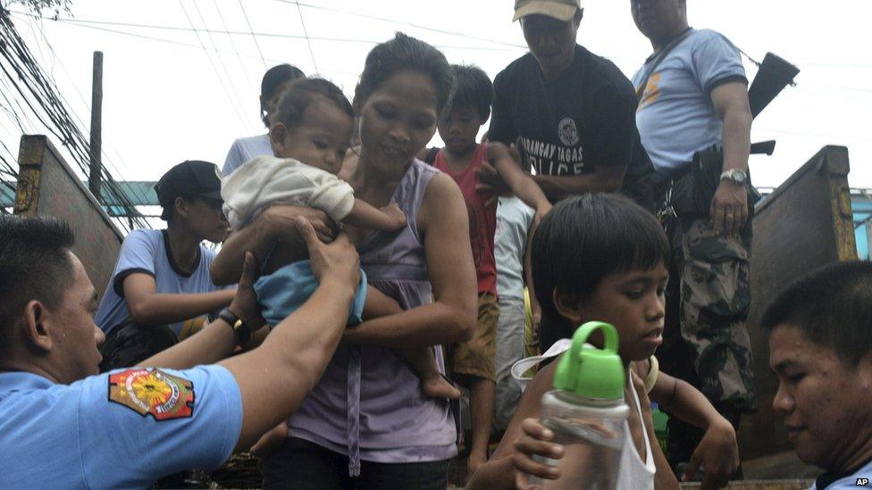 Residents living near the slopes of Mayon volcano are evacuated to public schools by police in anticipation of the powerful typhoon Haiyan, 7 November 2013