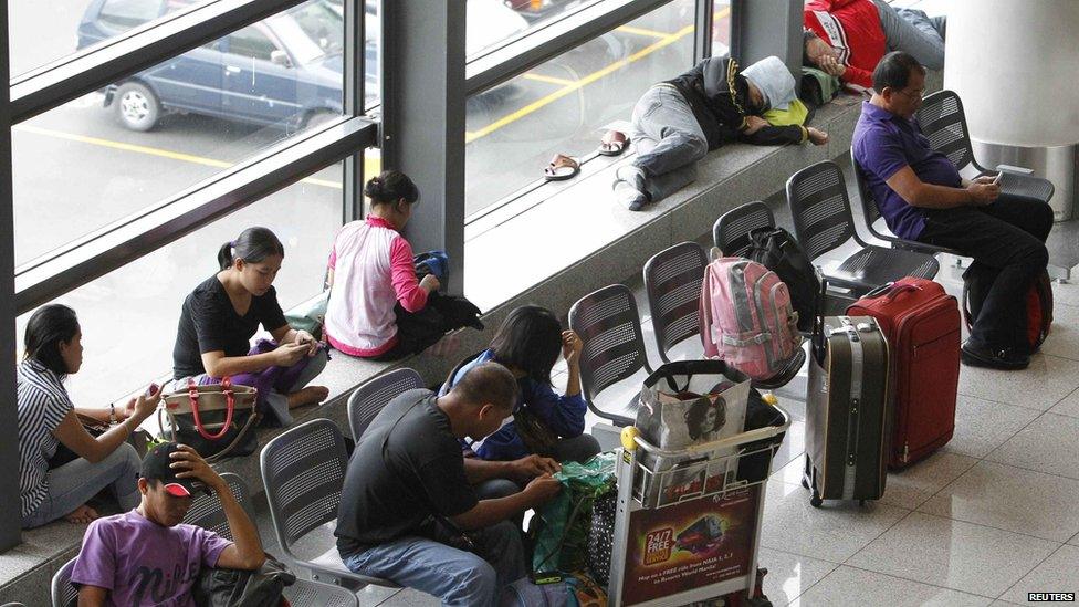 Stranded passengers wait at the lobby of Ninoy Aquino International airport in Pasay city, metro Manila, 8 November 2013