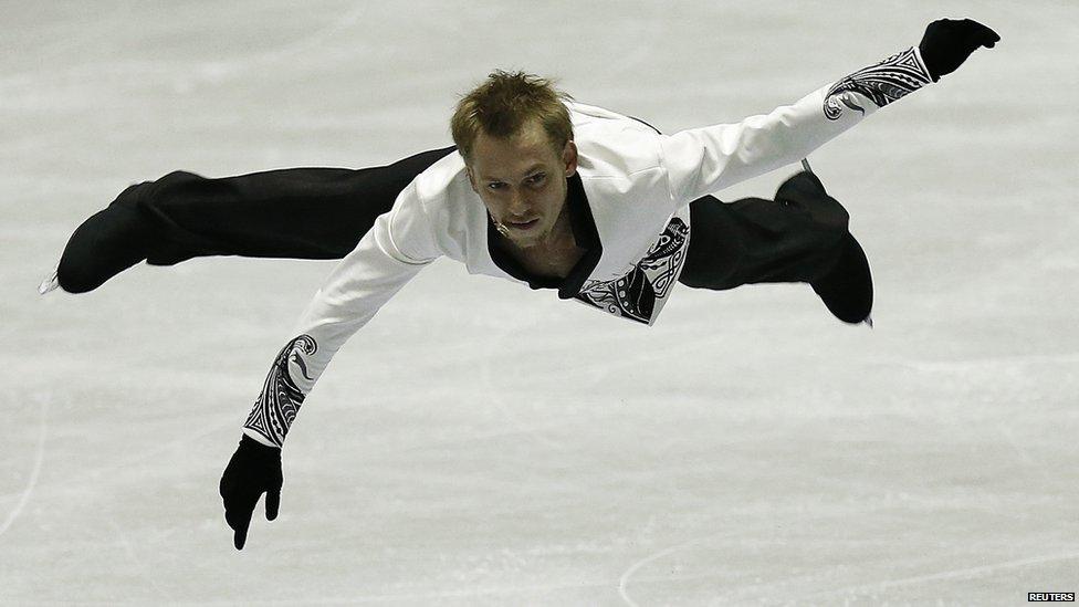 A man mid-air as he skates on ice