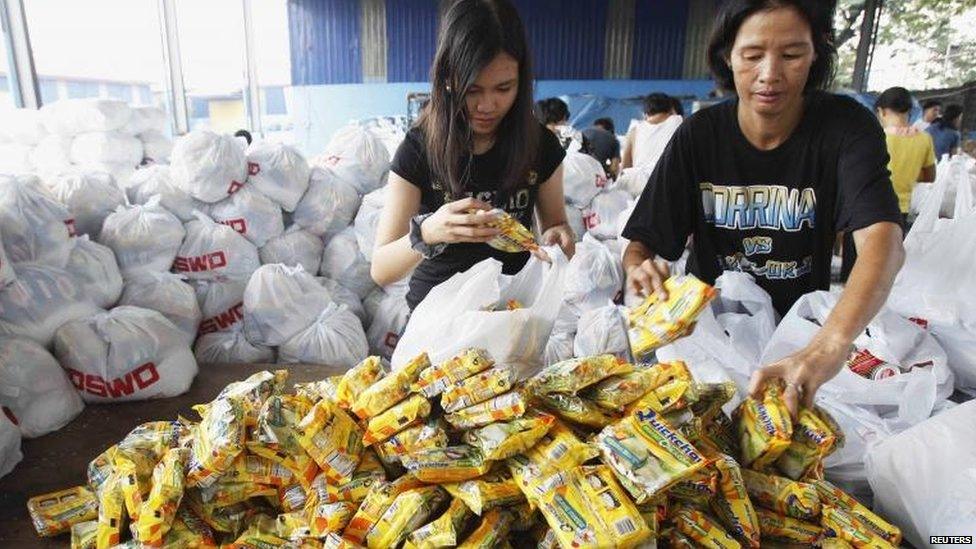 Volunteers pack relief goods in government warehouse