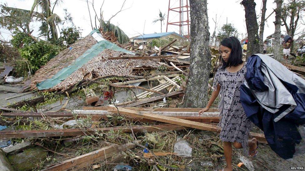 Girl searches for salvageable materials among debris in Tacloban. 9 Nov 2013