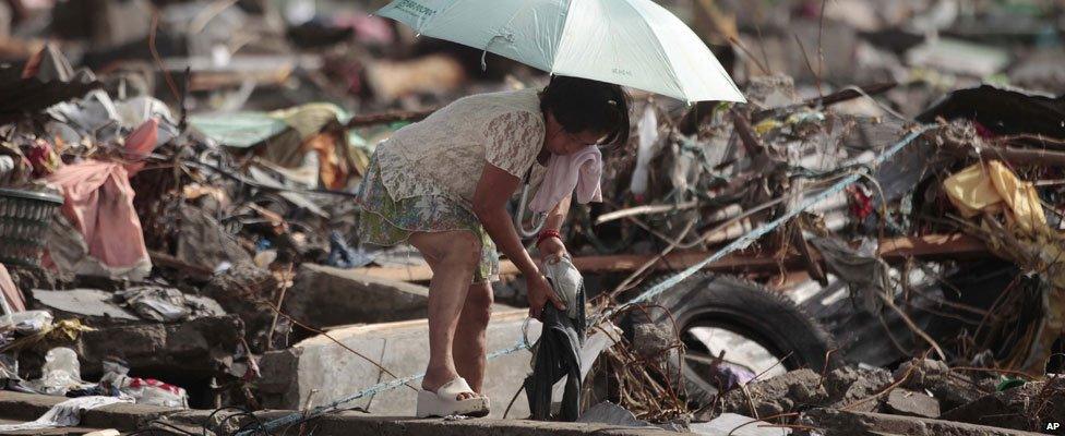 Woman sorts through belongings in Tacloban