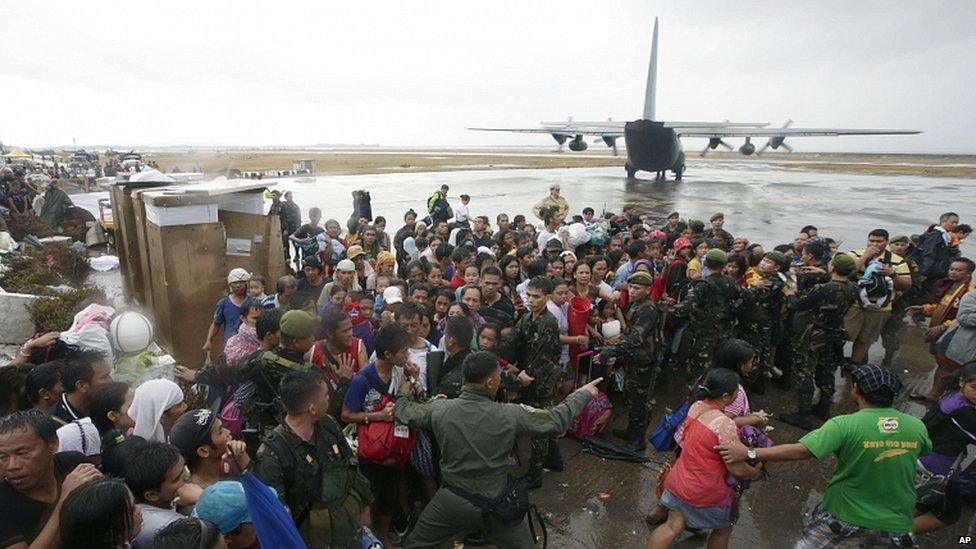 Typhoon survivors rush to get a chance to board a C-130 military transport plane out of Tacloban city, Leyte province, central Philippines