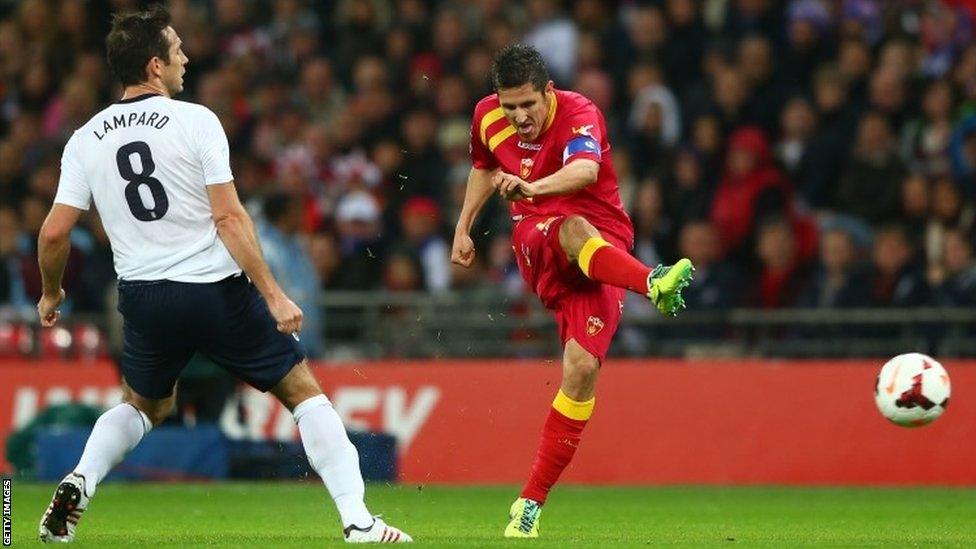 Stevan Jovetic of Montenegro takes a shot as Frank Lampard of England looks on during the 2014 World Cup qualifying match