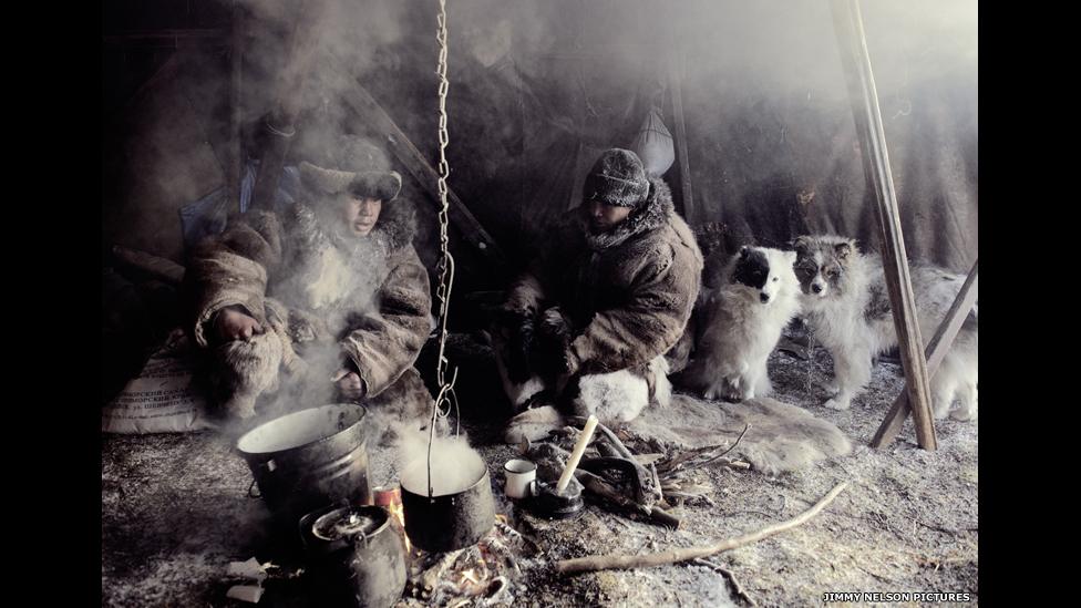 Chukchi from north-eastern Siberia inside a shelter with their dogs