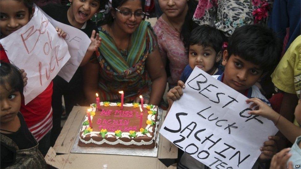 Indian cricket fans of Sachin Tendulkar hold placards and gather to cut a cake in his honour in Hyderabad, India, Wednesday, Nov. 13, 2013