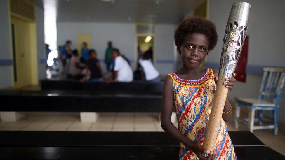 A young girl holds the Queen's Baton in the Outpatients Ward in Gizo Hospital in Gizo, Solomon Islands