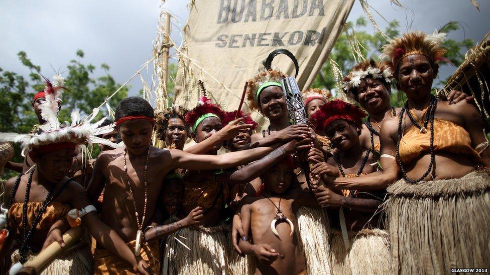 Traditionally dressed singers and dancers hold the Queen's Baton on the lagatoi, a processional canoe, that followed the relay route through the town in Port Moresby, Papua New Guinea.