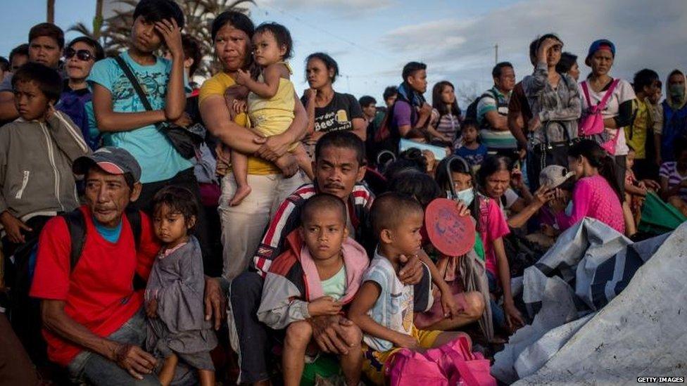 People wait at Tacloban airport, 16 Nov