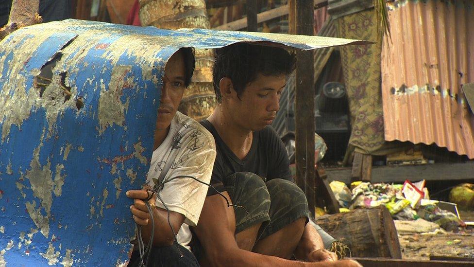 Two boys sheltering by a roadside in Tacloban, a city devastated by Typhoon Haiyan, in Leyte, central Philippines