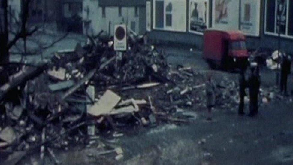 Rubble and a red van on the street after the blast