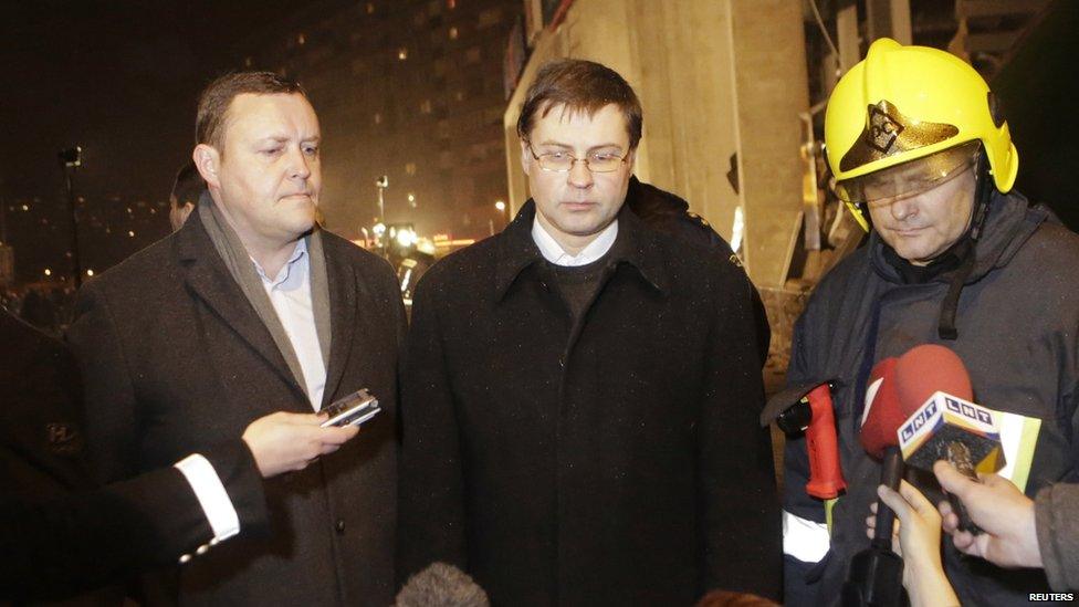 Latvia's Interior Minister Rihards Kozlovskis (L), Prime Minister Valdis Dombrovskis (C) and a senior emergency services official speak to the media near the collapsed Maxima supermarket in Riga on 21 November 2013