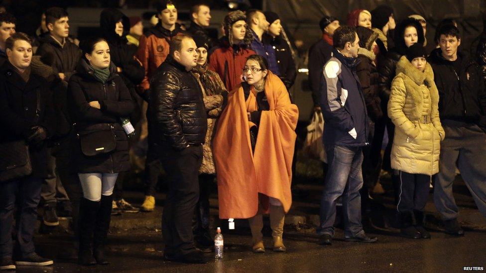 People gather near the collapsed Maxima supermarket in Riga