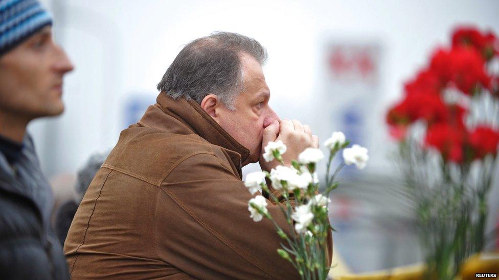 A man waits for news at the scene where the Maxima supermarket roof collapsed in Riga on November 22, 2013