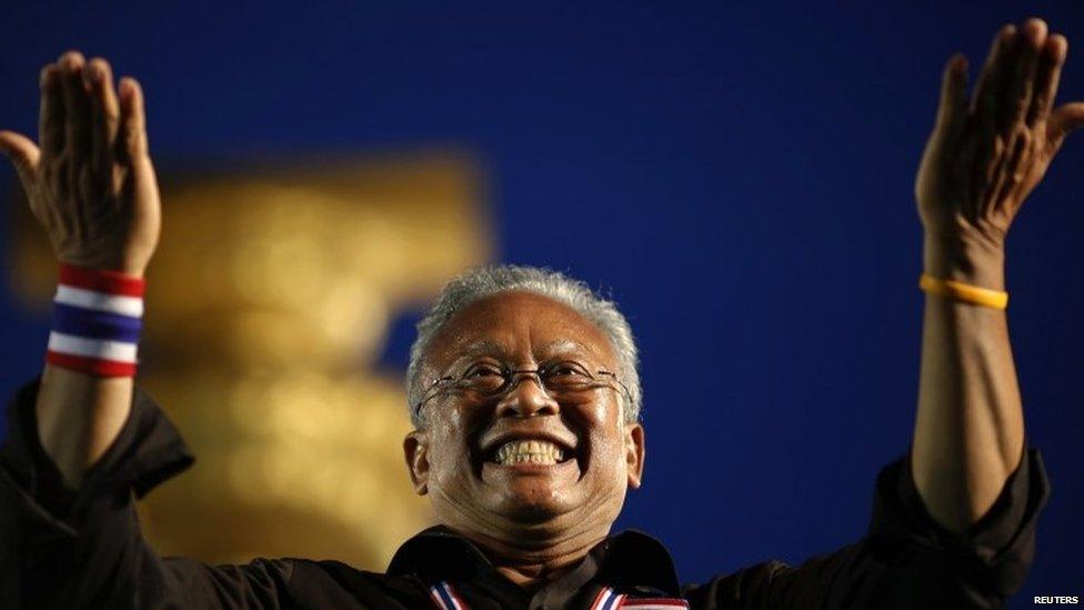 Suthep Thaugsuban, former deputy prime minister and protest leader, acknowledges the crowd at the Democracy monument in central Bangkok, where tens of thousands gathered in a protest against a government-backed amnesty bill, 24 November 2013