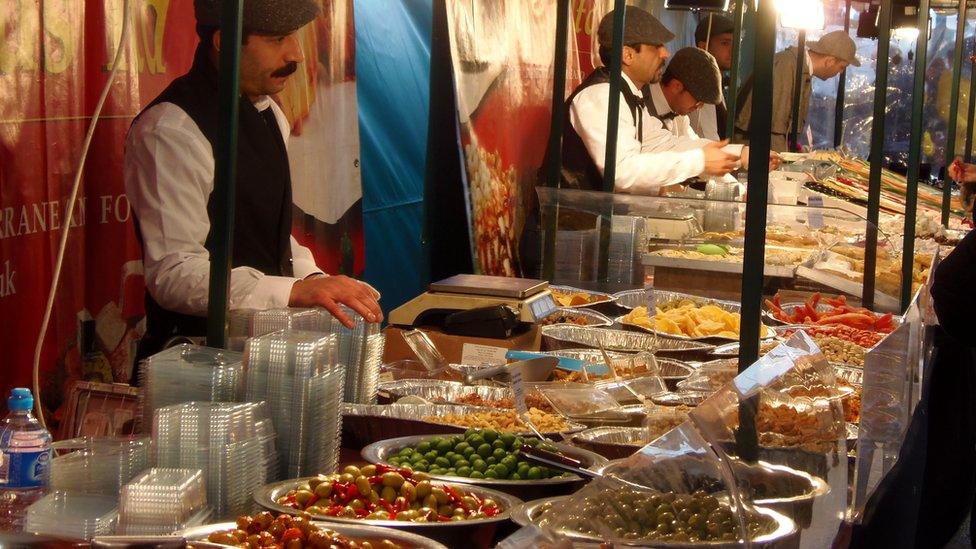 Men with moustaches selling olives