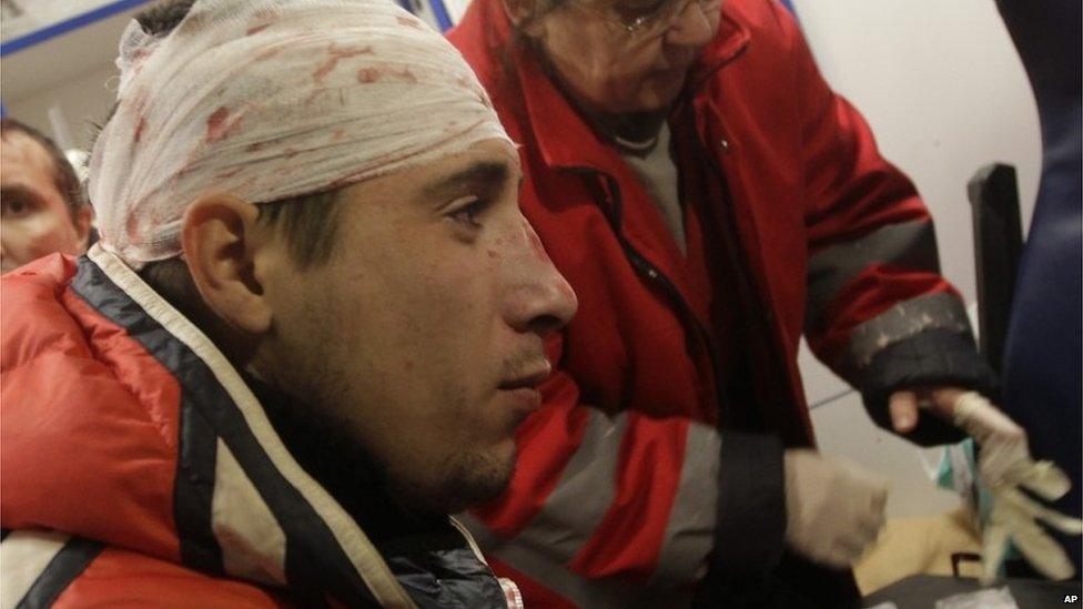 A protester receives medical help in ambulance after Ukrainian riot police broke up a rally
